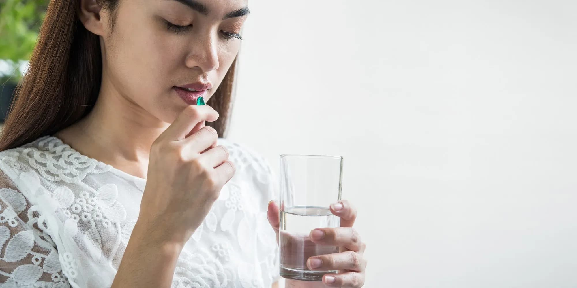 žena si bere vitamíny na akné